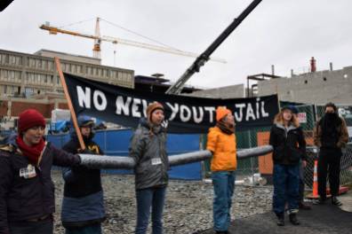 Protesters from the No New Youth Jail Coalition block entry points to the construction site, stopping supplies from entering. Liberation photo Lee Hessler.